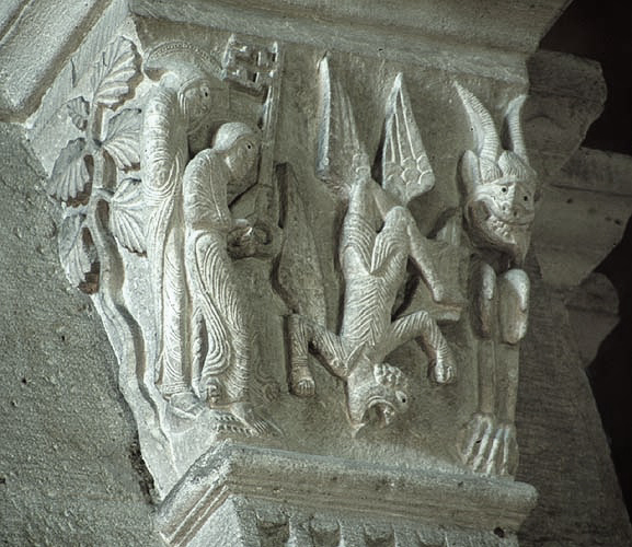 Romanesque carved capital showing Simon Magus falling headfirst while a demon watches